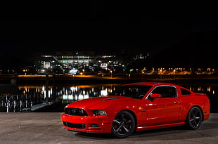 red Ford Mustang parked near bay during night time HD wallpaper
