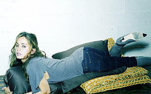 woman grey shirt and blue blue denim jeans lying on black textile HD wallpaper