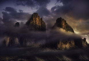 brown mountain surrounded by gray clouds