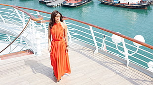 woman wearing orange sleeveless dress walking on ship deck during daytime HD wallpaper