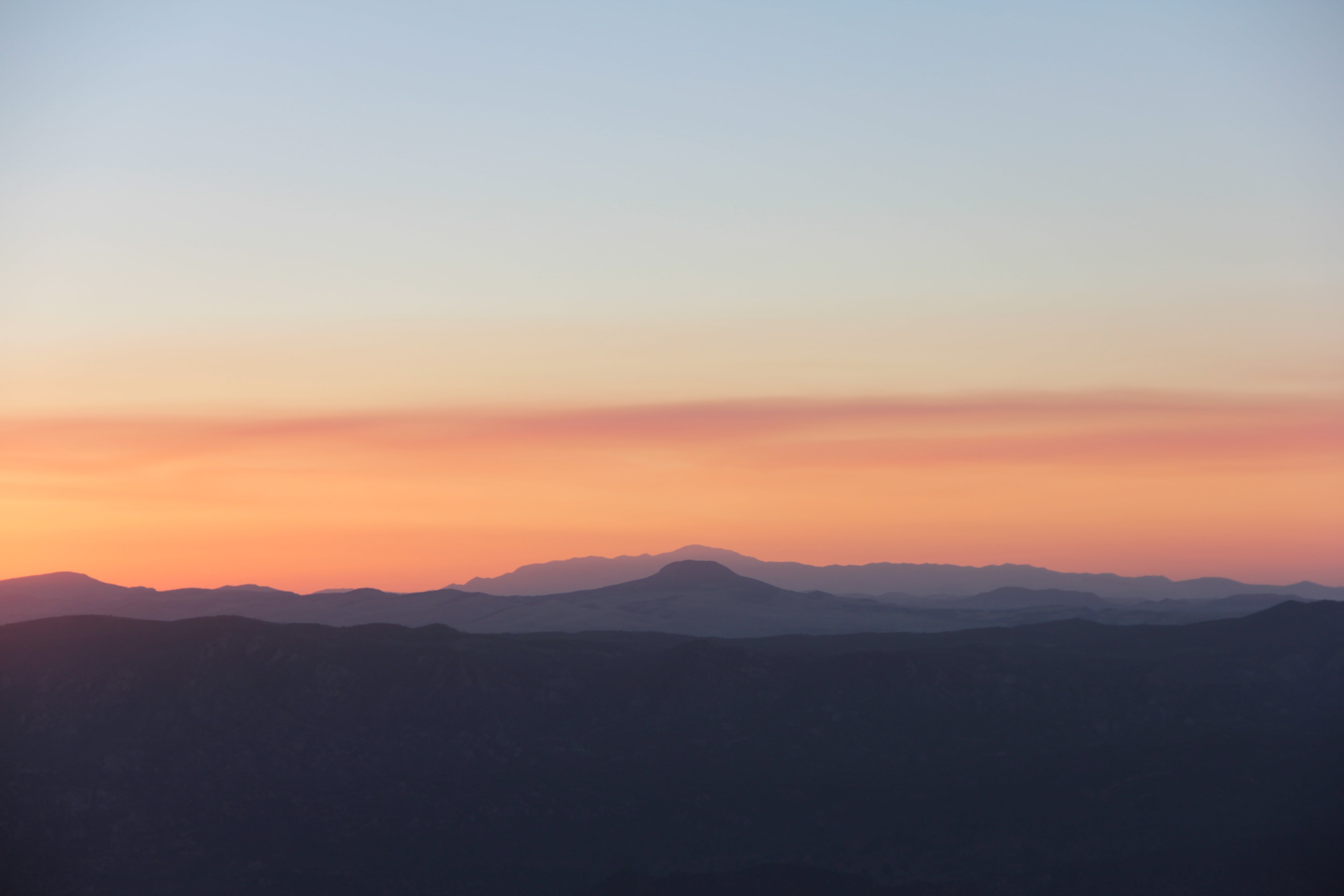 photo of sunset view of mountain with brown clear sky