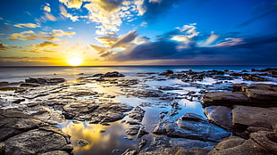 rock formation and body of water during daytime