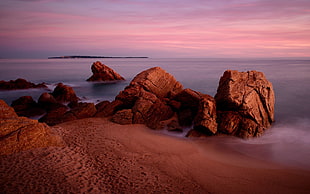 rock formation on sea during sunset