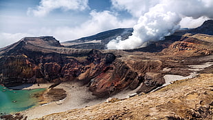 smoke coming out from a volcano crater HD wallpaper