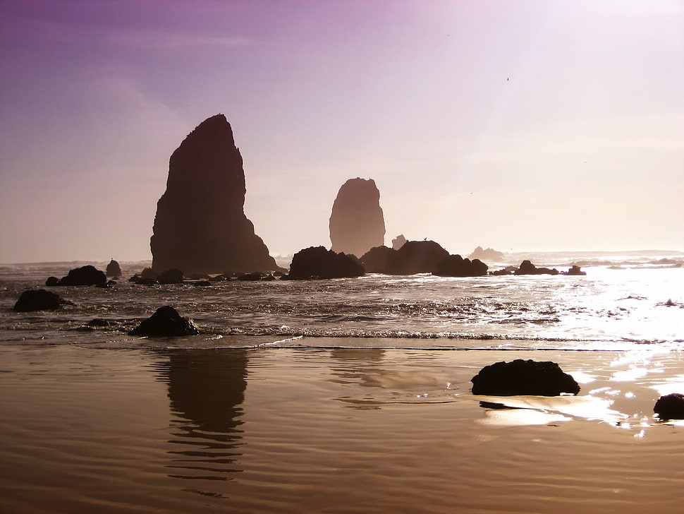 silhouette of rock formation and sea at daytime HD wallpaper