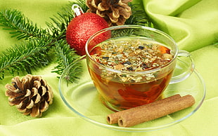 clear glass teacup filled with tea beside two baked sticks