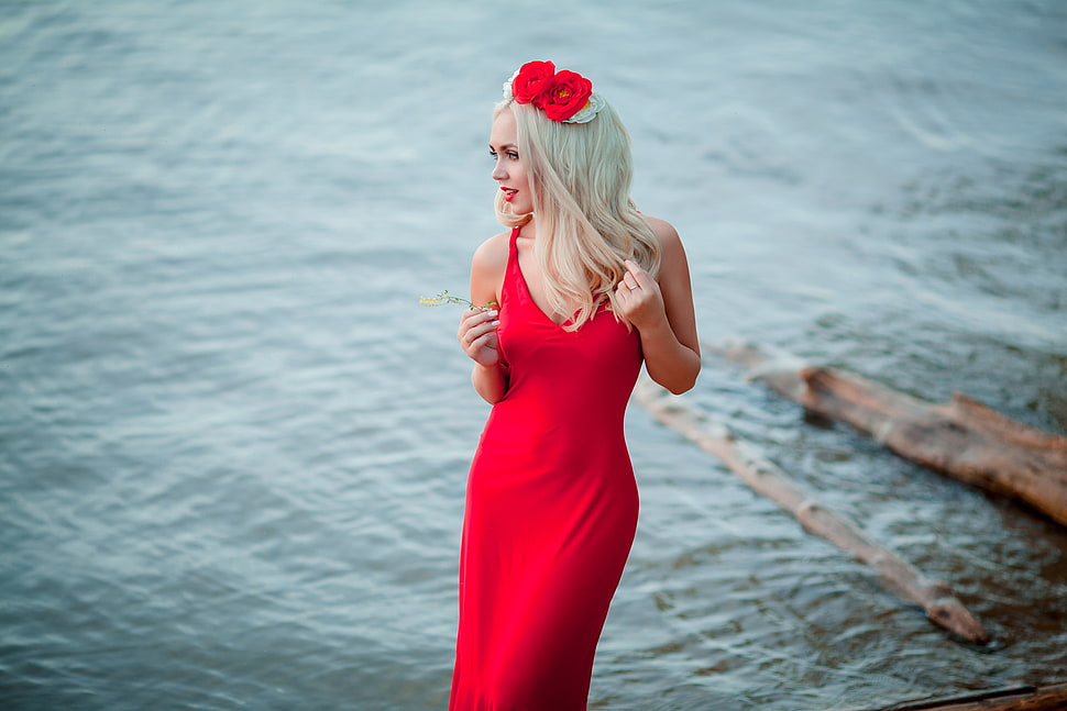 woman wearing red sleeveless dress beside body of water HD wallpaper
