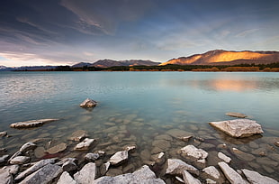 mountain near body of water under blue cloudy sky, tekapo