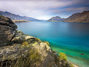 body of water surrounded by mountains during daytime