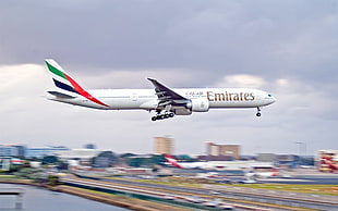 white Emirates Airplane landing during daytime HD wallpaper
