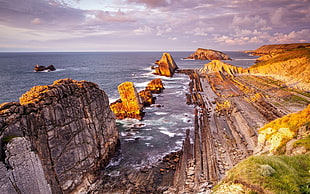 HDR photography of brown rock formation under the blue and white cloudy sky HD wallpaper