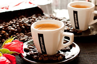 white ceramic coffee mug on black ceramic saucer