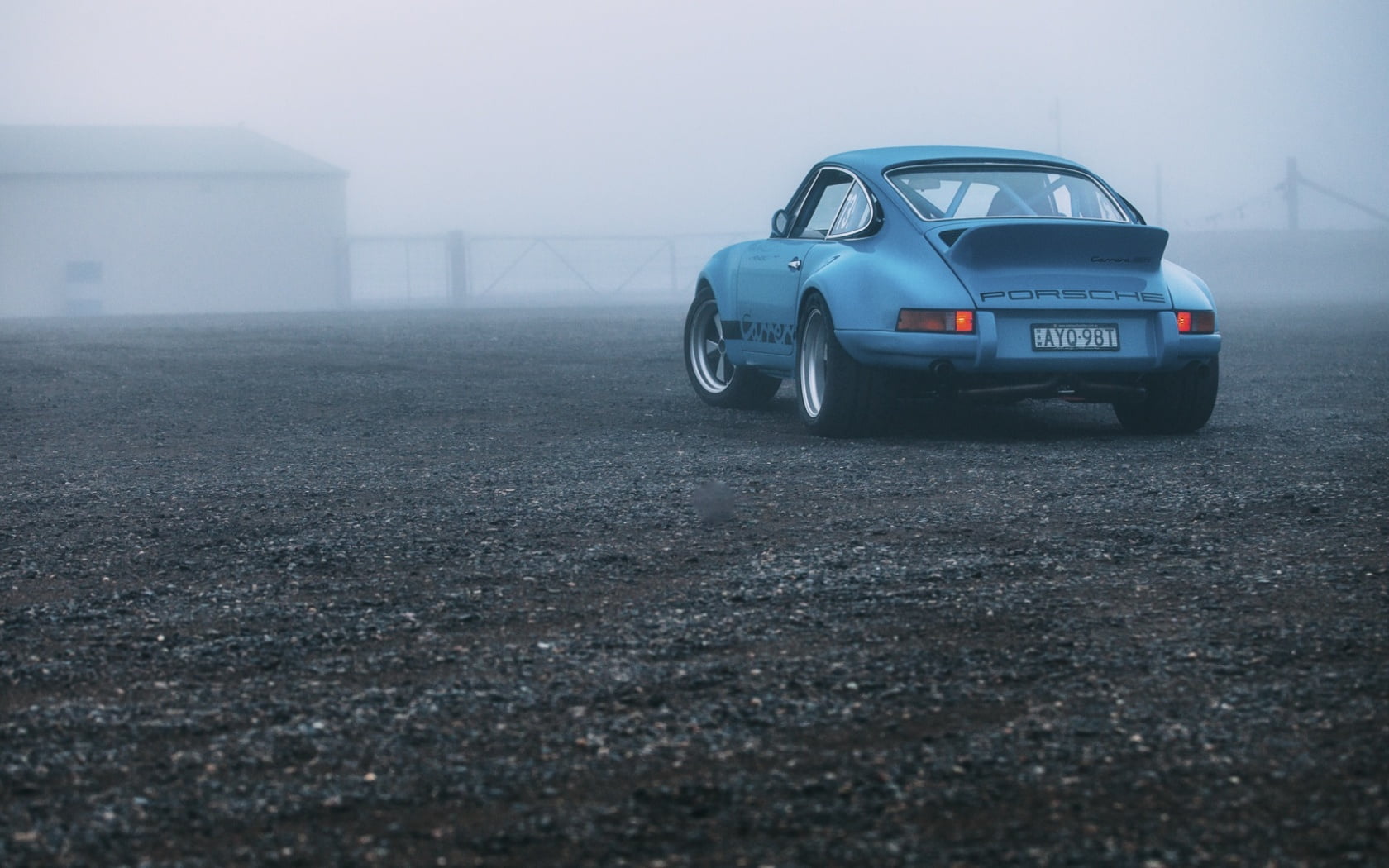 Silver porsche 911 parked on black asphalt road during night time