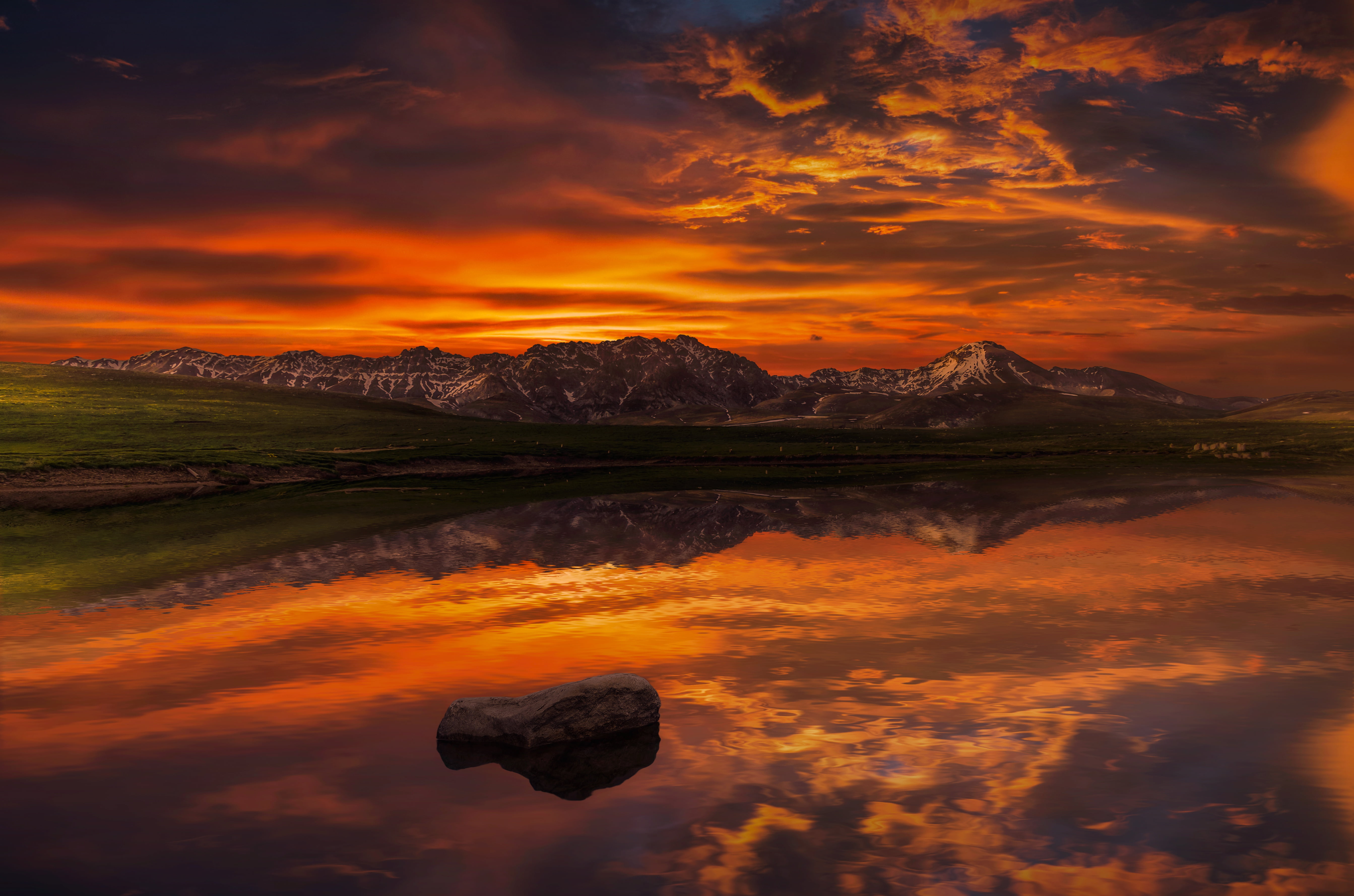 body of water and mountain during sunset