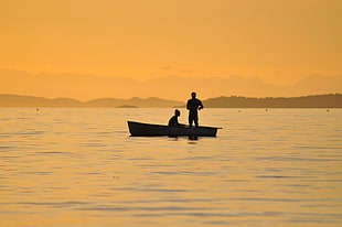 silhouette photo of two person on boat in middle of body of water during golden hour \ HD wallpaper