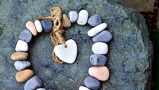 heart-shaped stone in middle of beaded stones on rock HD wallpaper