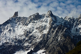 snow covered mountain under white clouds