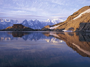 snow capped mountains beside body of water during daytime