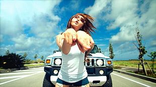 woman pointing fingers in front of Hummer on road at daytime HD wallpaper
