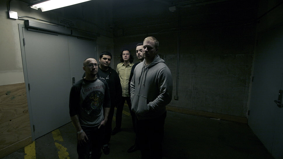 five men standing near gray roller shutter HD wallpaper