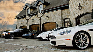 two white and two black cars in front of house HD wallpaper