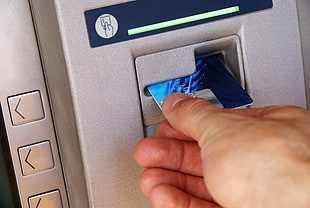person holding blue ATM card inserting on ATM machine HD wallpaper