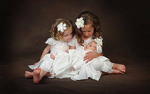 two girl wearing white shirts holding baby HD wallpaper