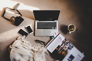 black and gray laptop computer beside iPhone and eyeglasses