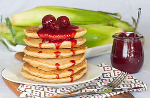 pancake with strawberry jam on top on white ceramic plater