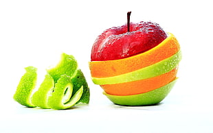 focus photography of red apple on slice of orange fruit