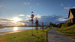 brown and white concrete house, sunset, river, clouds, grass