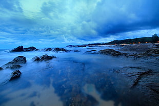 time lapse photography of rocks and nimbus clouds HD wallpaper