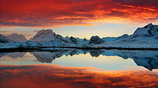 snowy mountain with orange clouds horizon photo