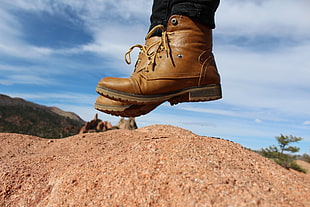 person wearing leather boots above ground