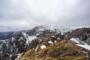 snowy mountain under cloudy sky