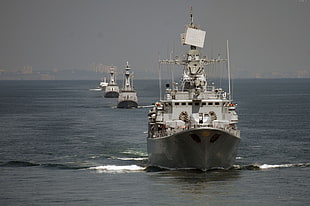 four gray-and-white boats in water