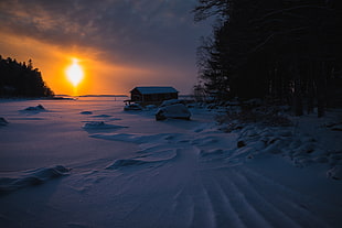 snow covered house and terrain during golden hour