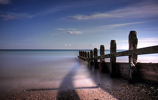 gray stones near sea and wall HD wallpaper