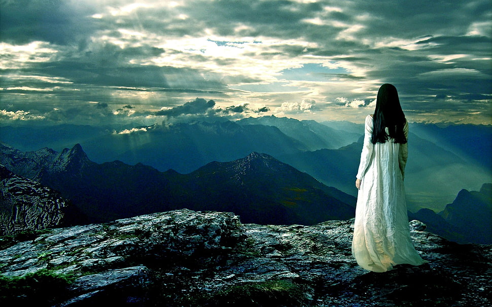 woman in white dress standing beside edge of mountain HD wallpaper