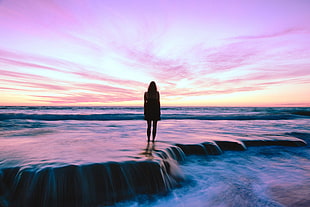 woman surrounded by water during dusk