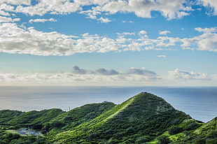 landscape photography of green mountains beside body of water