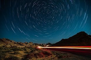 concrete road with mountain background at nighttime HD wallpaper