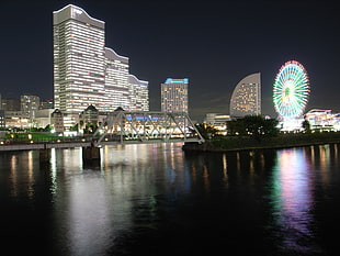 beige lighted concrete buildings near sea during night time, yokohama