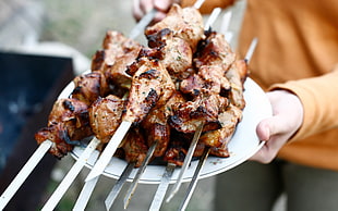 person showing barbecue on sticks onceramic plate HD wallpaper