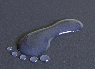 human foot water drop on black surface
