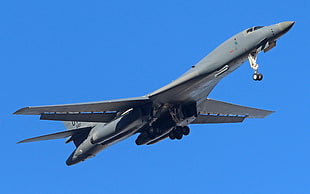 gray plane on mid-air under white sky during daytime