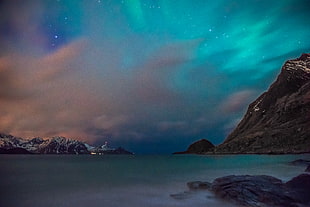 calm body of water beside mountain, norway