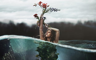 woman half submerged in water holding up a red flower half underwater photography HD wallpaper