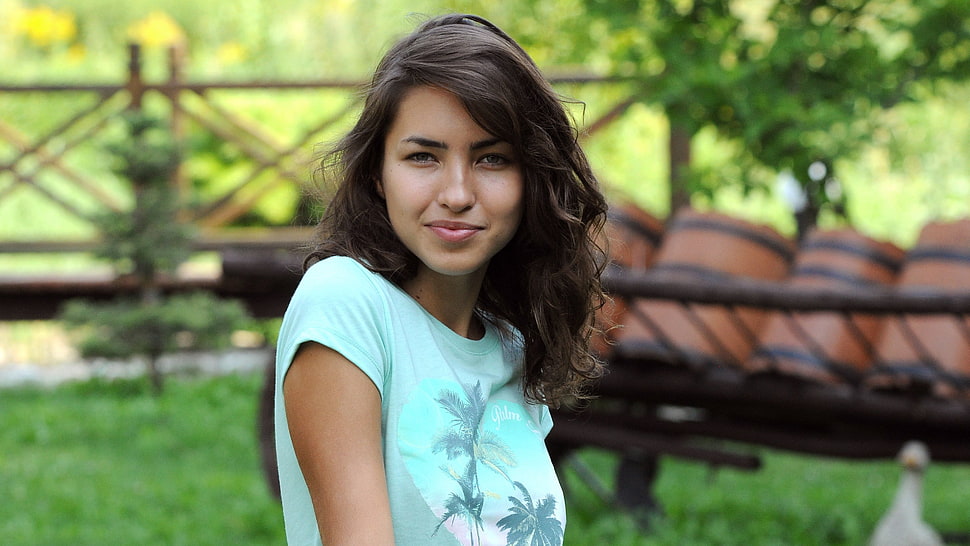 person taking photo of woman in blue crew-neck shirt in tilt shift photography HD wallpaper