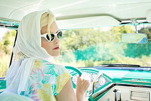 woman wearing white scarf and white and multi-colored flower printed top while holding steering wheel HD wallpaper